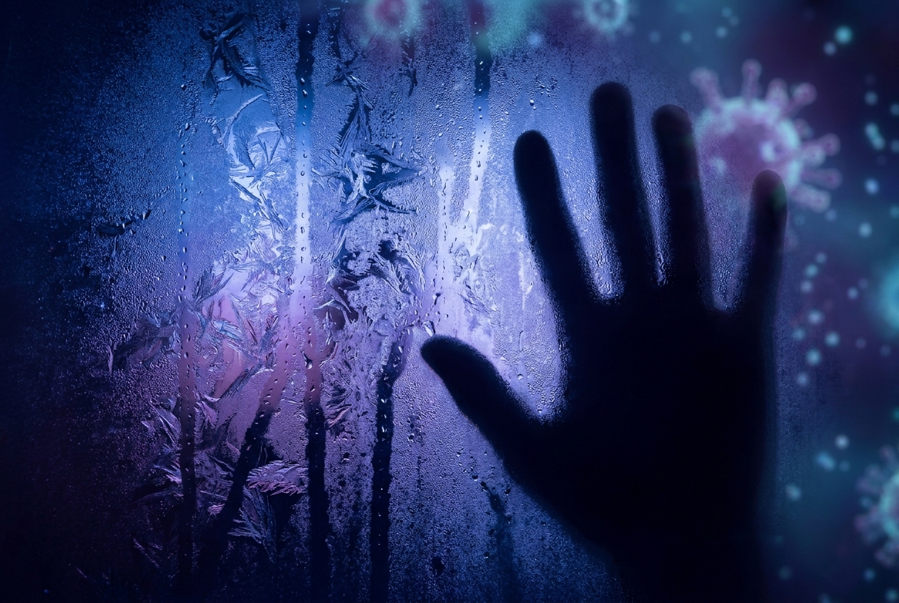 Macro shot of a frosted glass pane with branching condensation patterns and a silhouette of a hand.